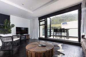 a living room with a coffee table and a large window at Mount Views in Mount Maunganui