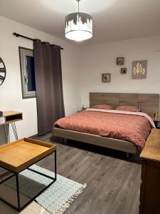 um quarto com uma cama e uma mesa em Magnifique Loft - Hyper Centre em Annemasse