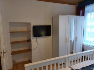 ein Schlafzimmer mit einem TV an der Wand und einer Treppe in der Unterkunft Ferienwohnung Alte Stadtmauer in Bamberg