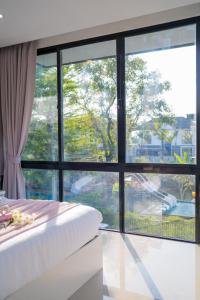 a bedroom with a large window and a bed at Snap stay pool villa pattaya พัทยา บ้านพักพัทยา พูลวิลล่าพัทยา in Ban Huai Yai