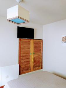 - une chambre avec un lit et une télévision murale dans l'établissement Casa Olivia, à Alta Gracia