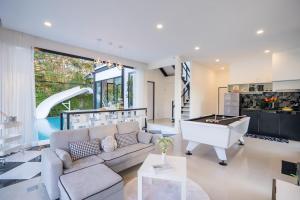 a living room with a couch and a pool table at Snap stay pool villa pattaya พัทยา บ้านพักพัทยา พูลวิลล่าพัทยา in Ban Huai Yai