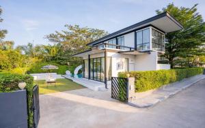a white house with a black roof at Snap stay pool villa pattaya พัทยา บ้านพักพัทยา พูลวิลล่าพัทยา in Ban Huai Yai