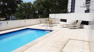 una piscina con sillas y una mesa en el patio en Apartamento completo Salvador, en Salvador