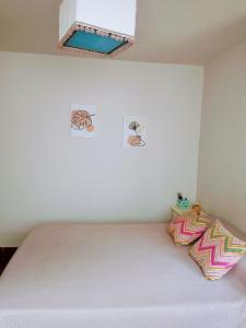 Ce lit se trouve dans un dortoir doté d'un mur blanc. dans l'établissement Casa Olivia, à Alta Gracia