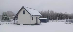 een klein huis met sneeuw op de grond bij Wierzchy 34 in Wierzchy
