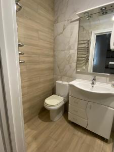 een badkamer met een toilet, een wastafel en een spiegel bij Apartments in Pyrogovo in Vinnytsya