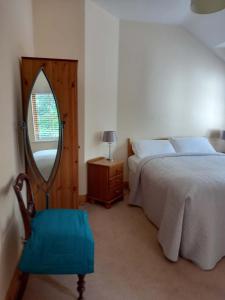 a bedroom with a bed with a mirror and a chair at The Courtyard, Castle Dargan in Ballygawley