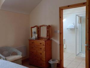 a bedroom with a dresser with a mirror on it at The Courtyard, Castle Dargan in Ballygawley
