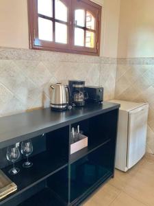 cocina con encimera con copas de vino y nevera en Loft privado cerca Parque en Mendoza