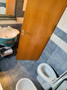 baño con aseo, lavabo y puerta en Loft privado cerca Parque en Mendoza