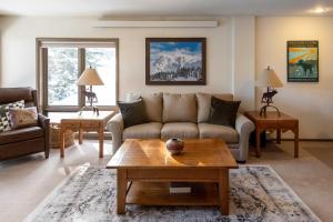 a living room with a couch and a coffee table at Steps to Ski Lifts - Condo with Walk-Out Patio! in Big Sky