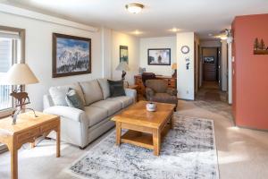 sala de estar con sofá y mesa en Steps to Ski Lifts - Condo with Walk-Out Patio!, en Big Sky