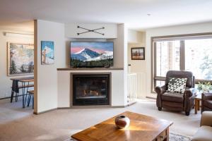 sala de estar con chimenea y TV en Steps to Ski Lifts - Condo with Walk-Out Patio!, en Big Sky