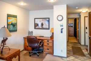 an office with a desk and a chair and a clock at Steps to Ski Lifts - Condo with Walk-Out Patio! in Big Sky