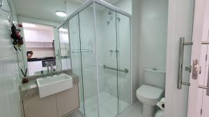 a bathroom with a glass shower and a toilet at Canal do Anfitrião | Studios Jauperi in Sao Paulo