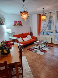 a living room with a red couch and a table at Benedicto in Ajo