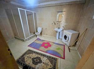 y baño con aseo y lavadora. en Suit home and room in city center en Erzurum