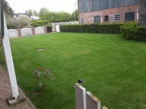 a yard with a brick building and a green lawn at Ferienwohnung 6 Fam. Ramm in Sibbersdorf