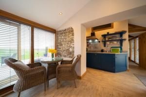 a kitchen with a table and chairs in a room at The Hen House at Accott Manor 