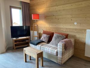 a living room with a couch and a television at Spacieux appartement 2 ch. au pied des pistes, proche ESF et après-ski, confort moderne - FR-1-634-8 in Avoriaz