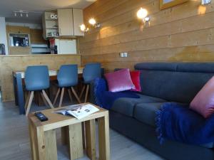 Una sala de estar con un sofá azul y una mesa. en Appartement 3 pièces pour 6/7 pers avec 2 salles de bains, buanderie, casier à skis et wifi - FR-1-634-11, en Morzine