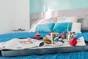 uma bandeja com pequeno-almoço em cima de uma cama em Casa Acqua Marina - 1 min from the sea, Wi-Fi & Air Conditioning, Sea View Balcony em Bordighera mais 27 fotografias