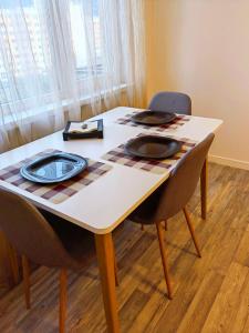 une table à manger avec deux chaises et un tissu de table dans l'établissement Alexander Apartments Kyustendil, à Kyustendil
