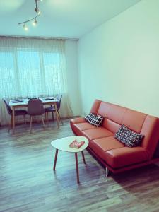 a living room with a red couch and a table at Alexander Apartments Kyustendil in Kyustendil