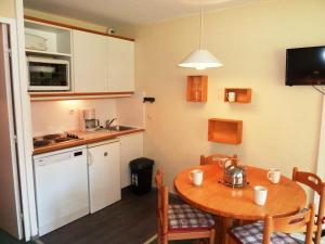 a small kitchen with a wooden table and a table and chairs at Studio Avoriaz, 1 pièce, 4 personnes - FR-1-634-28 in Avoriaz