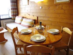 a wooden table and chairs with a table and a bed at Studio Avoriaz, 1 pièce, 4 personnes - FR-1-634-30 in Avoriaz