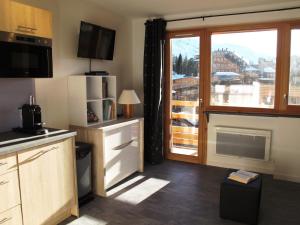 a kitchen with a fireplace and a large window at Studio Avoriaz, 1 pièce, 4 personnes - FR-1-634-31 in Avoriaz