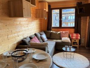 a living room with a couch and two tables at Appartement 2 pièces proche pistes, commerces et restaurants - Capacité 4 personnes - FR-1-634-43 in Avoriaz +8 photos