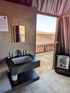 ein Bad mit einem Waschbecken und Blick auf den Strand in der Unterkunft Desert Magic Camp & Resort in Wadi Rum