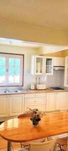 une cuisine avec une table en bois et une table et des chaises dans l'établissement La KazaDette, à Lamentin