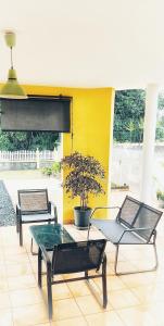 2 chaises et une table avec un pot sur la terrasse dans l'établissement La KazaDette, à Lamentin