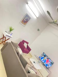 a living room with a couch and a ceiling fan at PARADISE FB in Cotonou