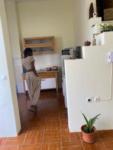 Una mujer parada en una cocina con una barra en Hostel Mindelo, en Mindelo