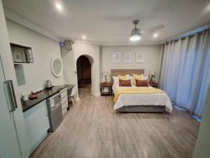 une grande chambre avec un lit et une cuisine dans l'établissement 1 on Fairway, à Bloemfontein