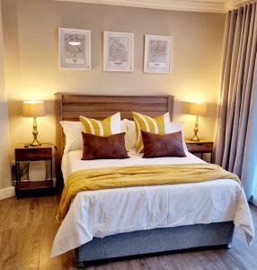 - une chambre avec un grand lit, des oreillers et 2 lampes dans l'établissement 1 on Fairway, à Bloemfontein