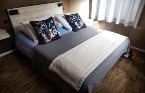 um quarto com uma cama grande com almofadas em Gite Auberge Les Cascades em La Mongie