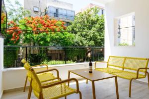 d'un balcon avec deux chaises, une table et une fenêtre. dans l'établissement Seeds of Gold by HolyGuest, à Tel Aviv