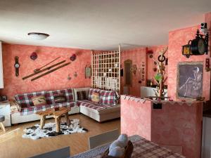 a living room with pink walls and a couch at Appartamento montano in La Thuile