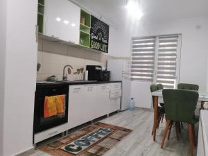 a kitchen with white appliances and a table with chairs at Casa Potcoava in Târgu-Mureş