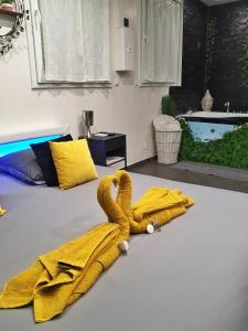 - une serviette jaune sur un lit dans la chambre dans l'établissement Suite Jacuzzi Privatif Plage Des Catalans, à Marseille