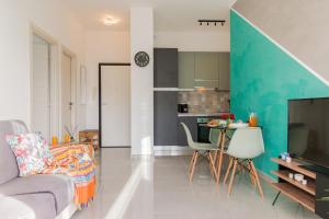 uma sala de estar com um sofá e uma mesa com cadeiras em Casa Acqua Marina - 1 min from the sea, Wi-Fi & Air Conditioning, Sea View Balcony em Bordighera