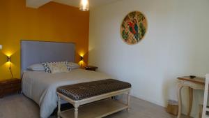 a bedroom with a bed with a bench in it at Lou pinsan in Camaret-sur-Aigues +5 photos