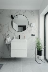 a bathroom with a white sink and a mirror at Aparthotel Nest Inn Meteor in Cluj-Napoca