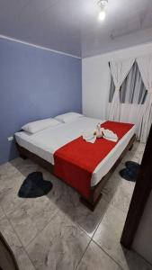 a bedroom with a large bed with a red blanket at Casa vista de luna in Guaria