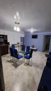 a room with blue chairs and a table and a kitchen at Casa vista de luna in Guaria